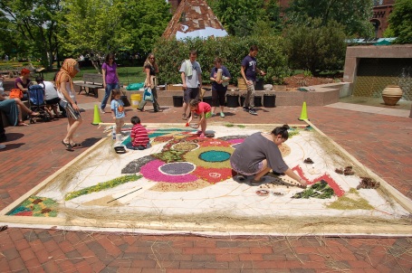 Visitors add natural materials to the ephemeral art piece at Garden Fest.